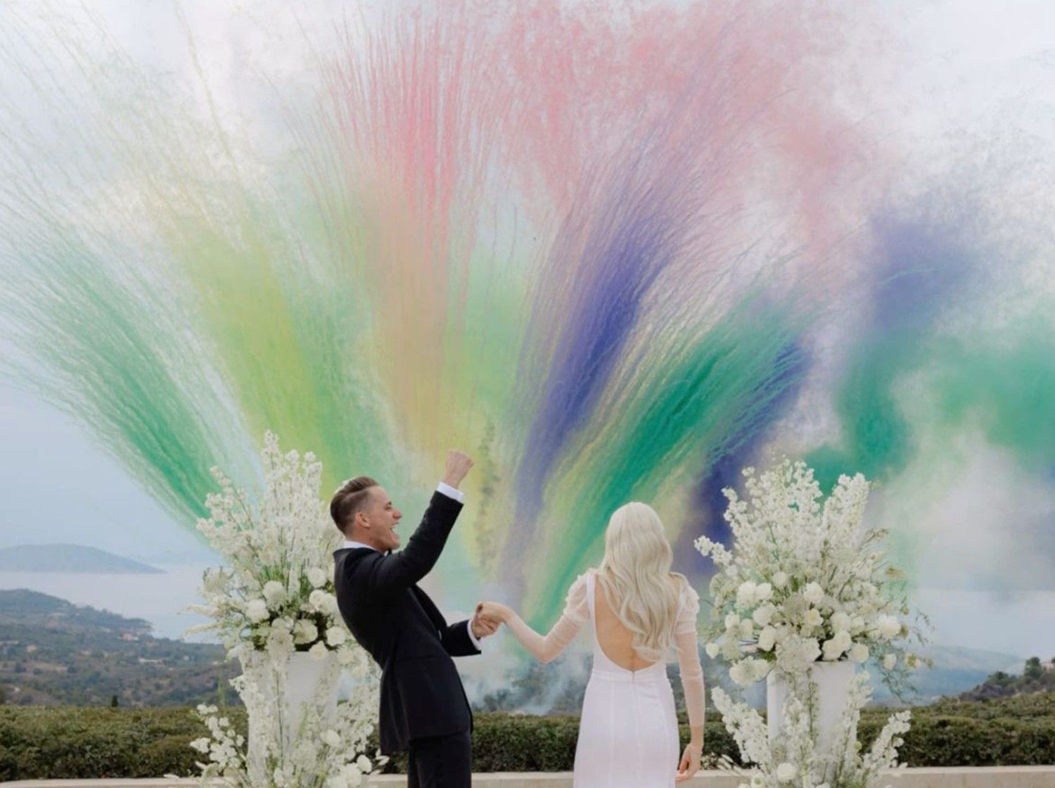 Bride and groom celebrate with vibrant coloured smoke mine on their wedding day